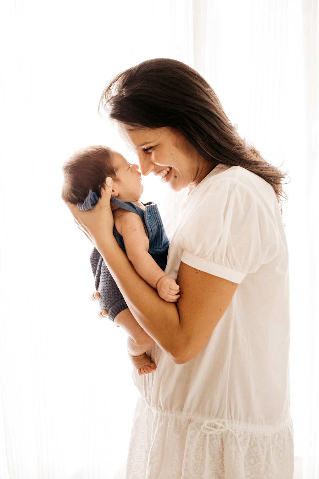 Side View Photo of Smiling Woman Carrying Her Baby